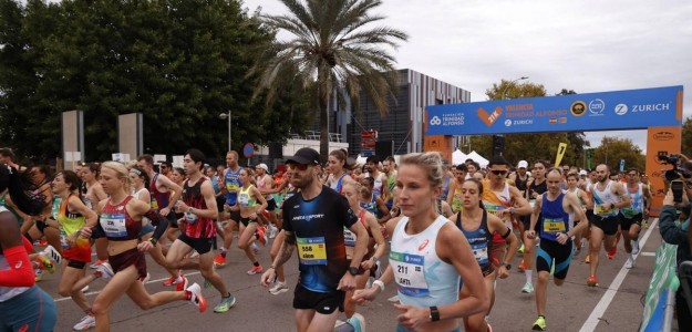 Corredores en el Medio Maratón Valencia con animación fallera de fondo